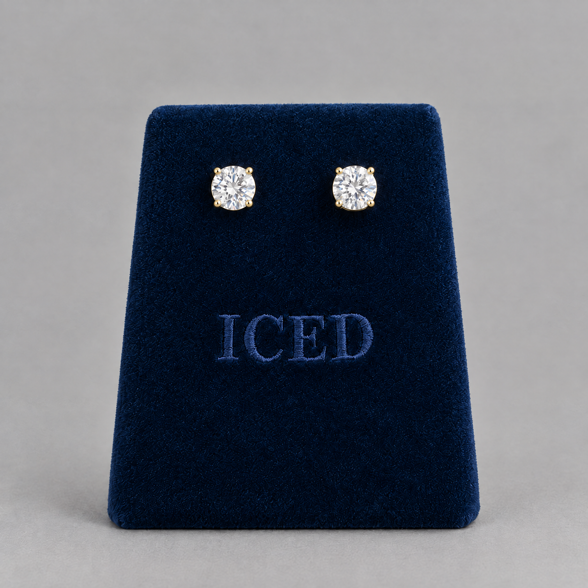 Gold moissanite stud earrings on Iced velvet stand